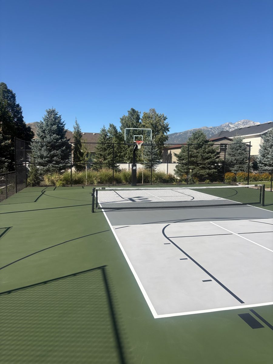 Finished Lehi post-tension court looking down the slate gray playing zone toward the basketball hoop