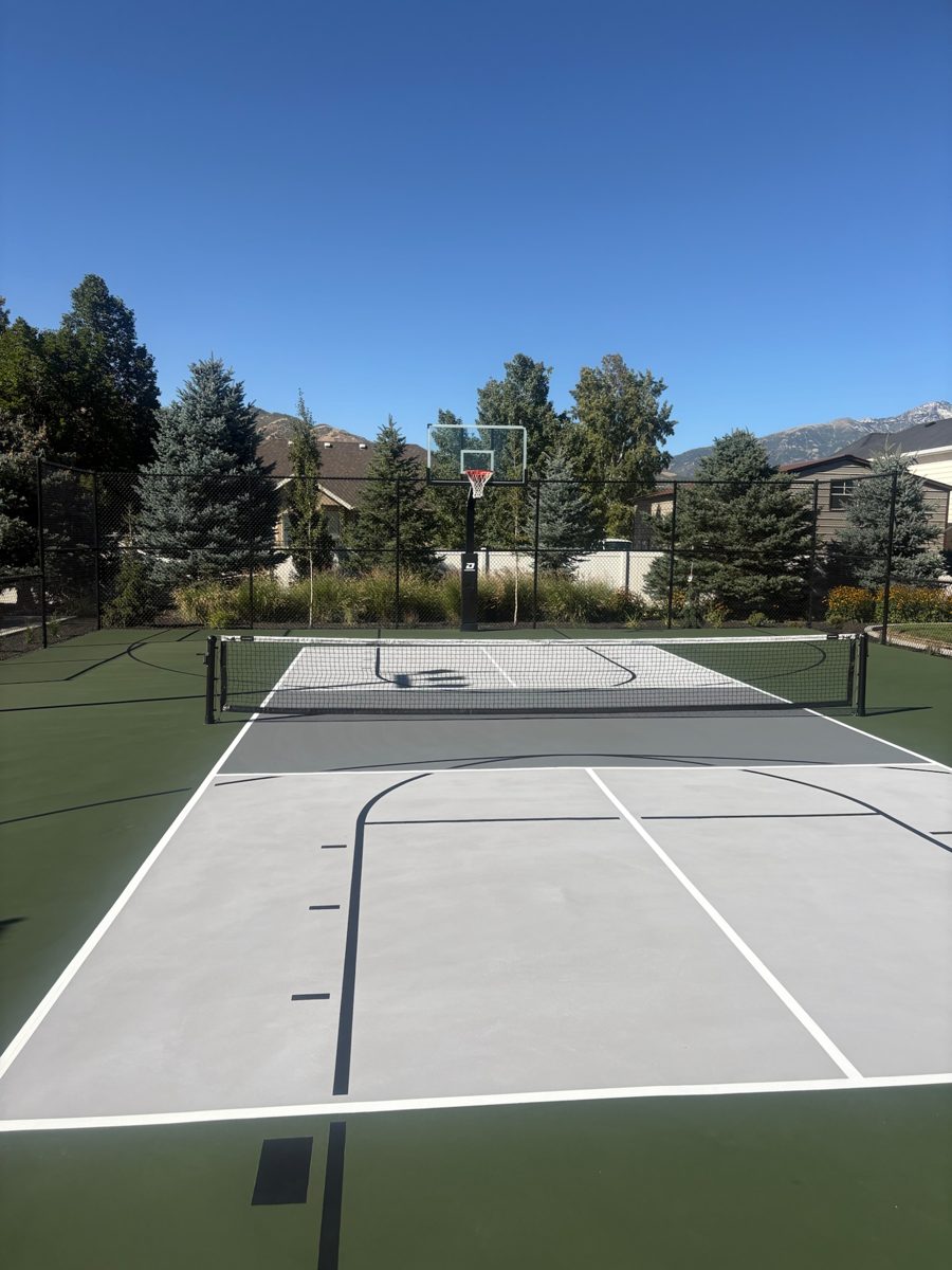 Rebuilt post-tension backyard pickleball and basketball court in Lehi, Utah with a forest green surround, slate gray playing zone and in-ground hoop