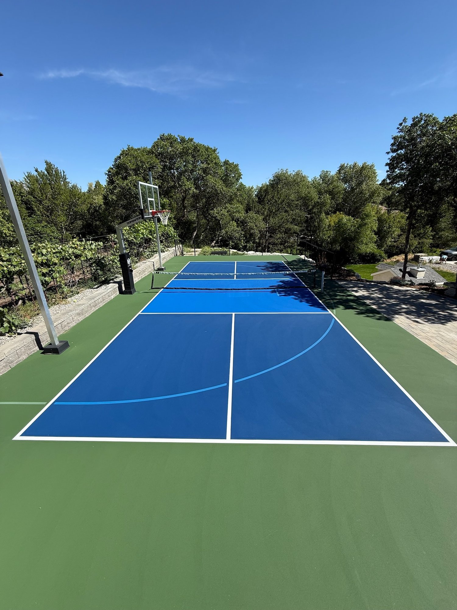 Blue and green multi-sport court combining basketball and pickleball lines
