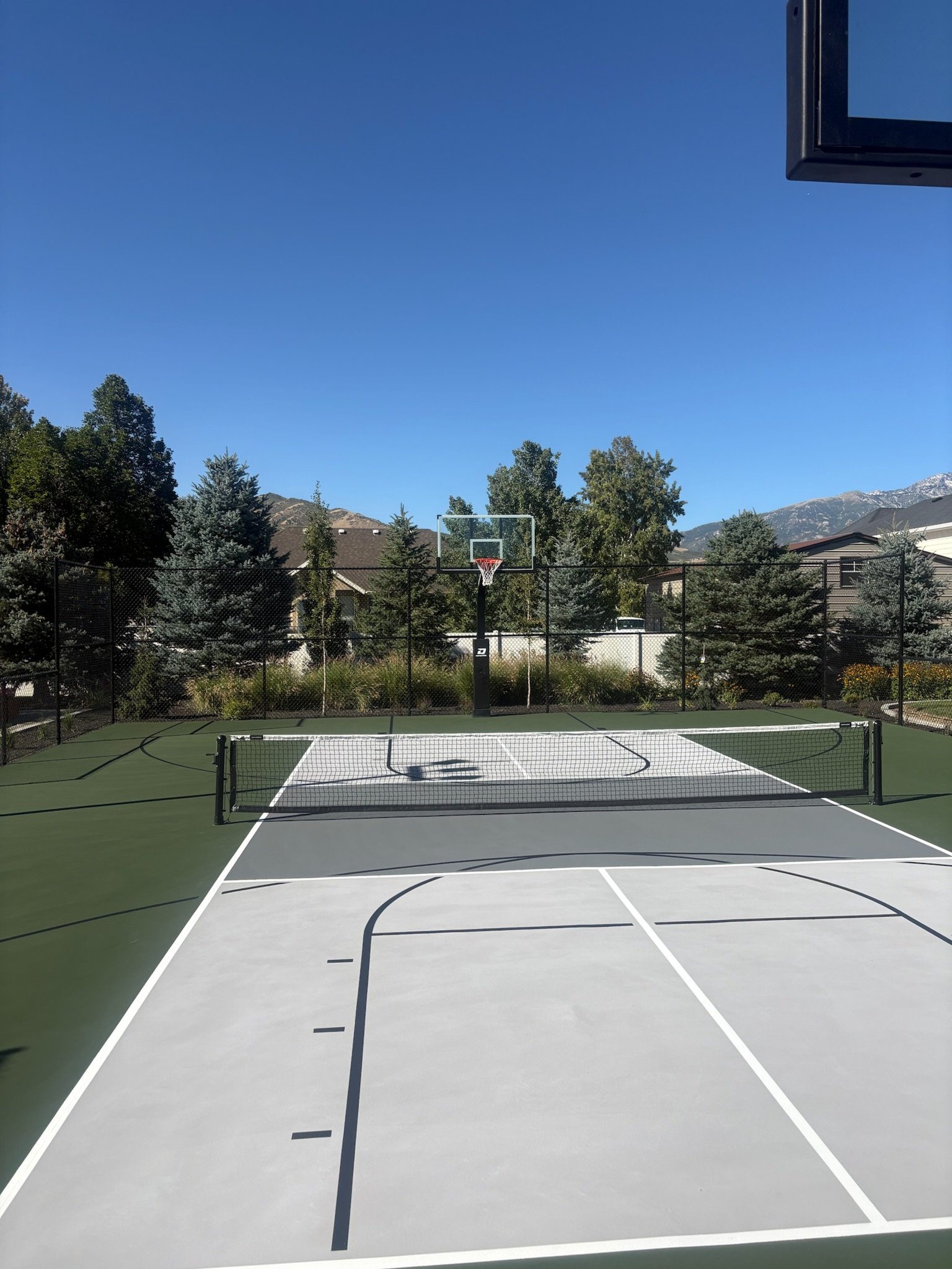 Backyard multi-sport basketball and pickleball court with a mountain view