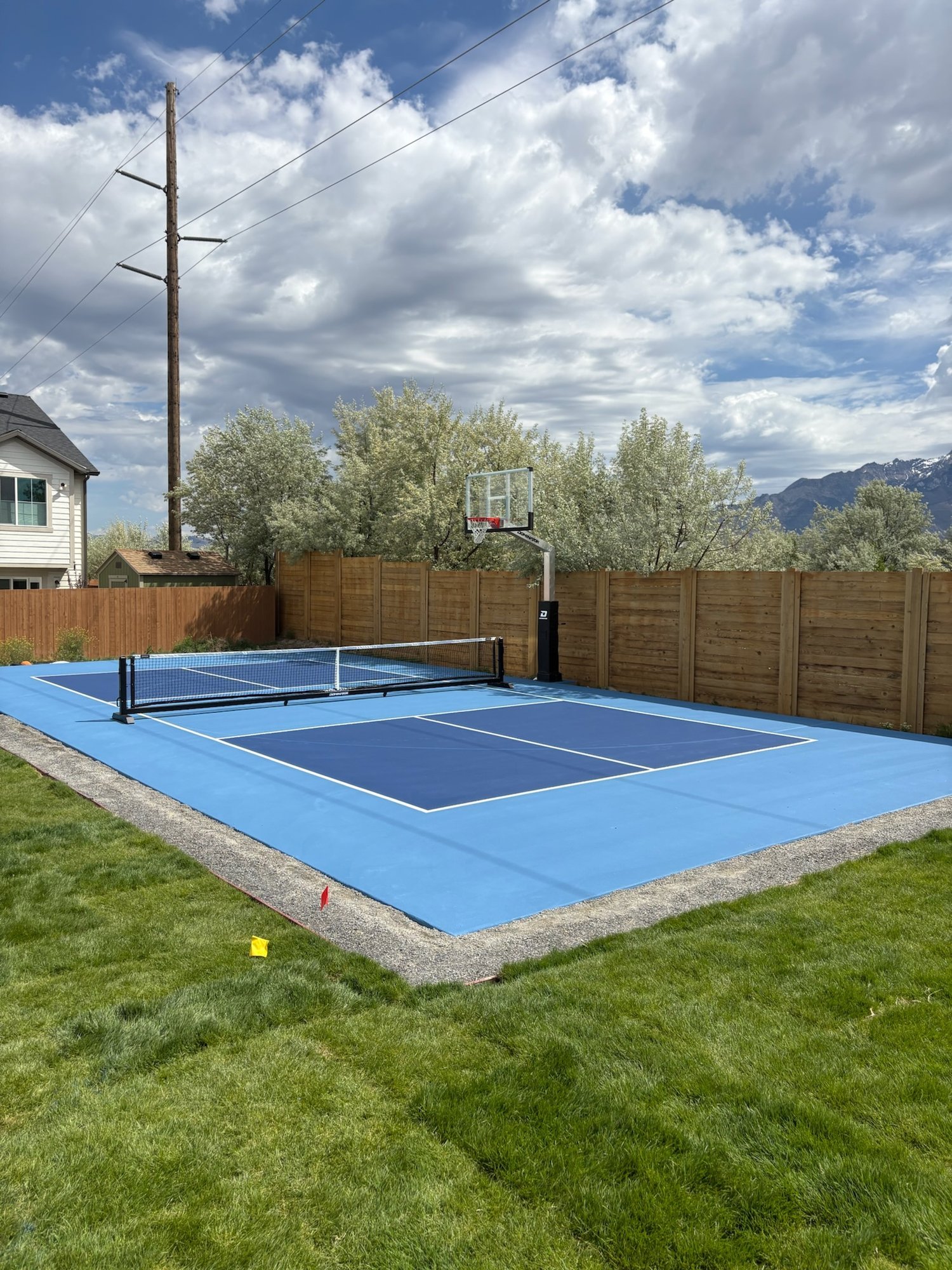 Resurfaced two-tone blue backyard pickleball and basketball court in Utah
