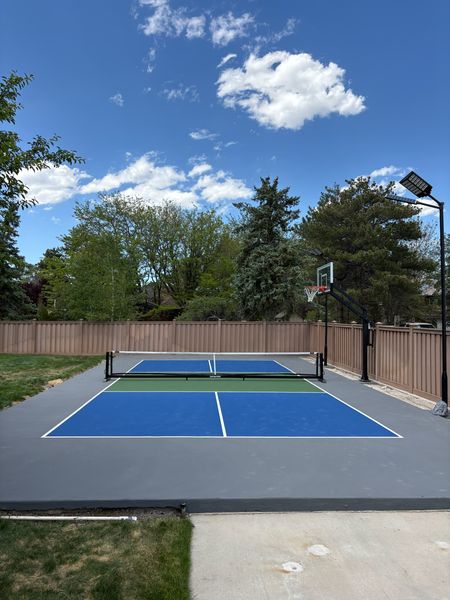 Backyard Blue Pickleball Court with Basketball Hoop and Court Lighting by Precision Pro Courts
